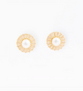 A pair of gold-toned circular earrings with a textured sunburst pattern surrounding a central white pearl, displayed on a clean white background.