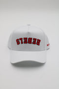 A white baseball cap with 'REBEKS' embroidered in red arched letters on the front, shown against a light gray background.