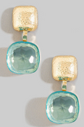 Pair of earrings with gold and blue square stones on a light gray background