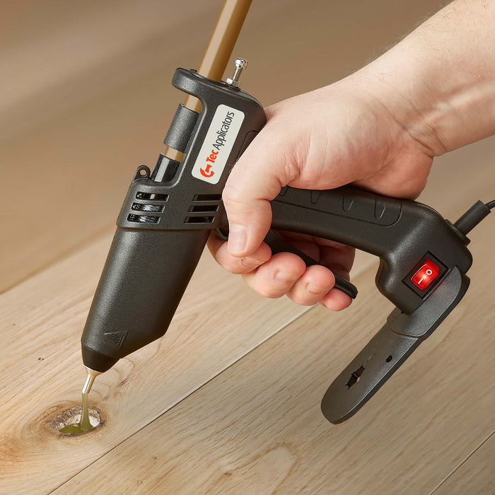A controlled bead of adhesive is applied into a wood knot using the Tec 305 glue gun from Power Adhesives in a surface repair scenario