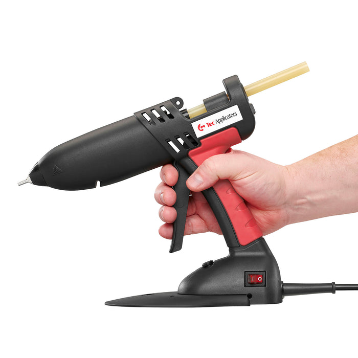 In-hand view of the Power Adhesives Tec 830 glue gun showing trigger reach and ergonomic handle design