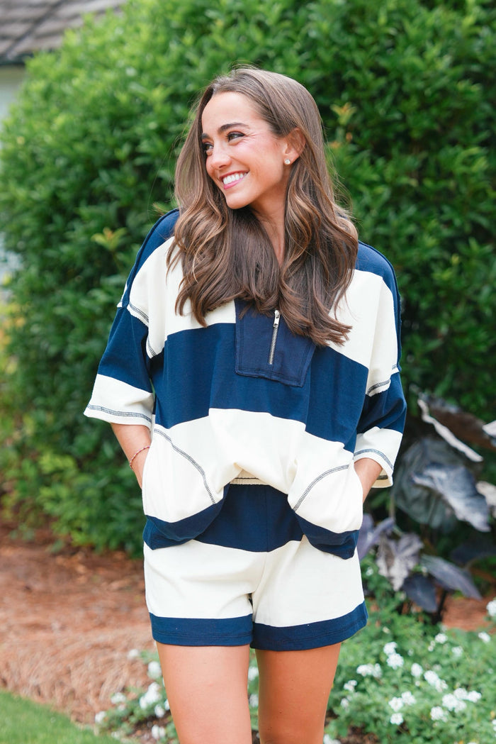 Woman wearing a striped sweater and shorts in an outdoor setting