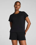 Woman wearing a black outfit on a gray background