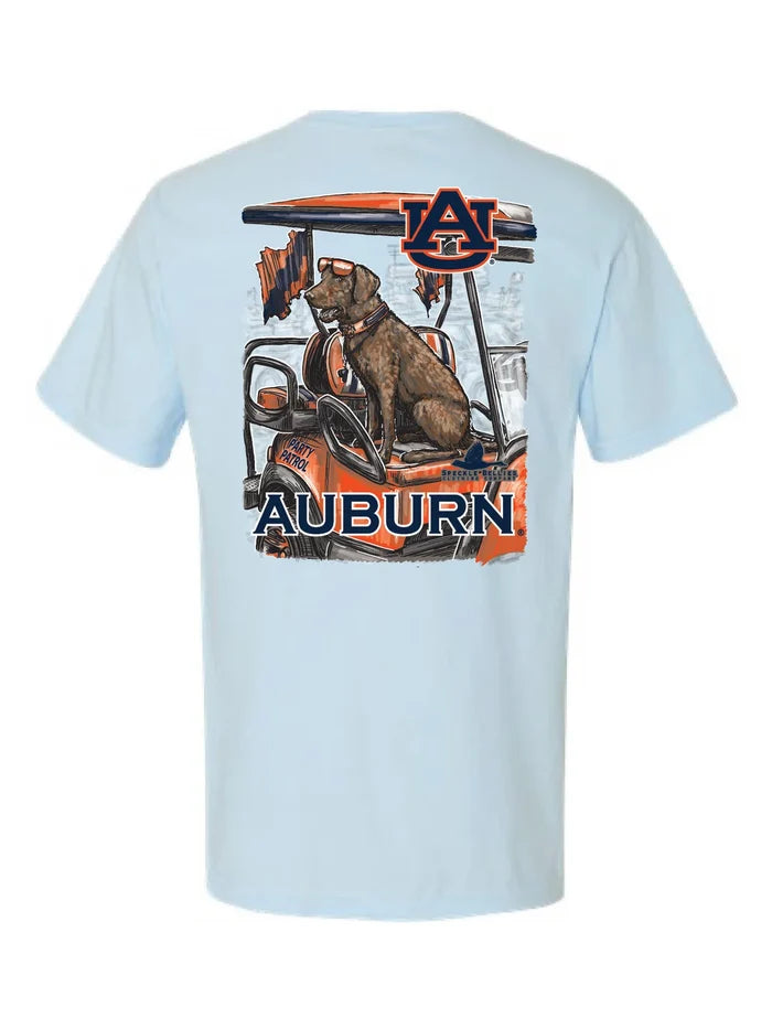 A light blue short-sleeve t-shirt shown from the back, featuring a large graphic print of a dog sitting in an orange and black golf cart with the Auburn logo and 'AUBURN' text.