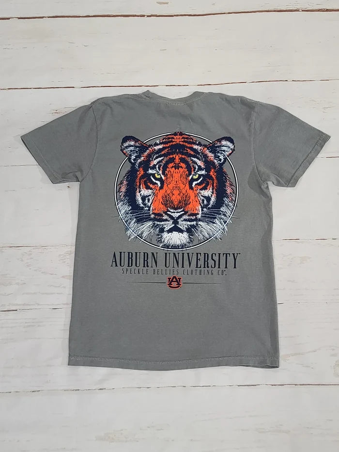 A gray short-sleeve t-shirt featuring a large graphic of an orange and black tiger face inside a circular frame, with 'AUBURN UNIVERSITY' printed below in black and a small Auburn logo. The shirt is laid flat on a white wood plank background.
