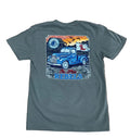 A dark gray t-shirt laid flat on a rustic wooden background, featuring a large graphic print on the back with a blue vintage pickup truck, a cowboy, a horseshoe, and the text 'The Old Rebels'.