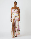 Woman wearing a strapless, floral-patterned gown with a slit on a white background