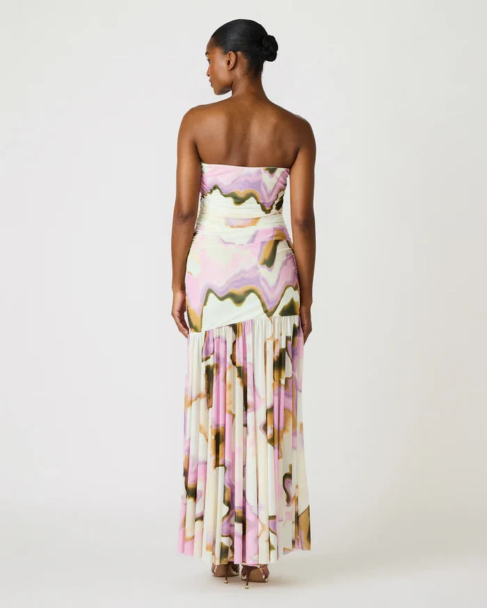 Woman wearing a strapless floral dress with fringe details on a white background