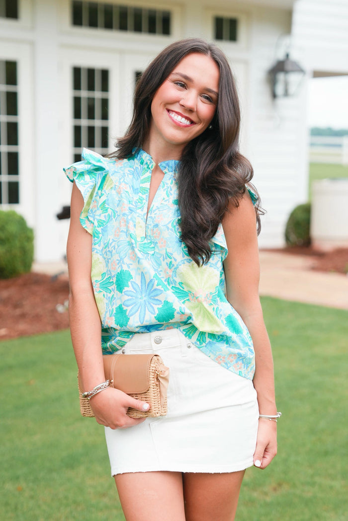 Woman wearing a floral top and white skirt outdoors