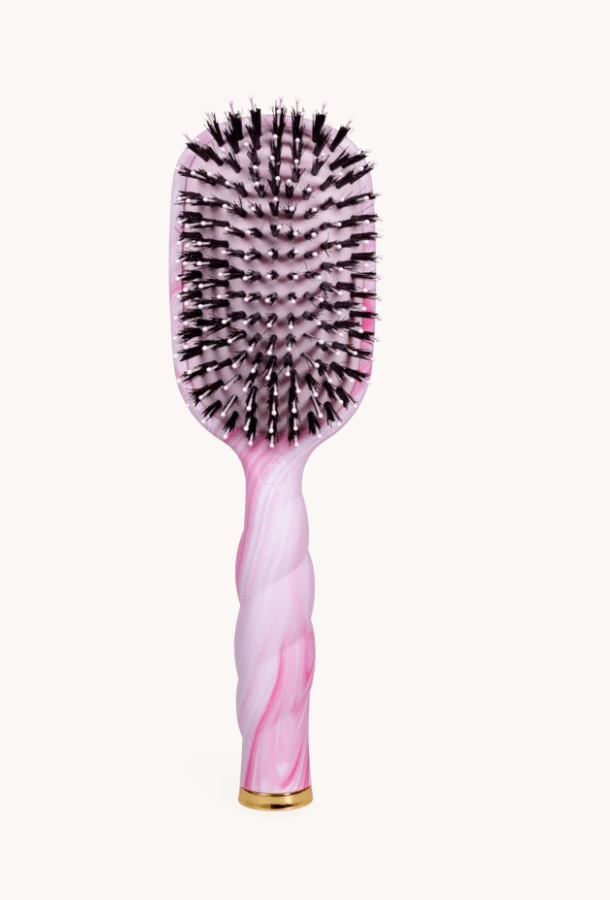 Pink hairbrush with black bristles on a white background