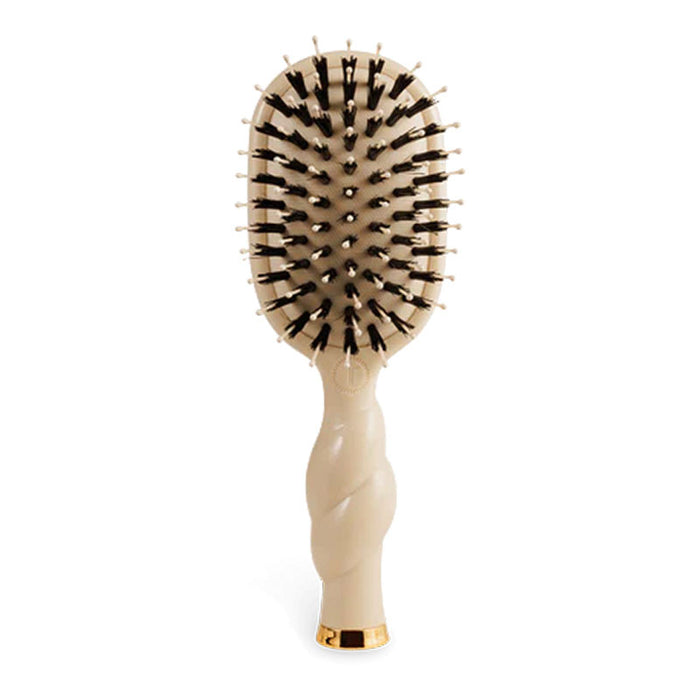 Cream hair brush with black bristles and a beige swirl handle on a white background