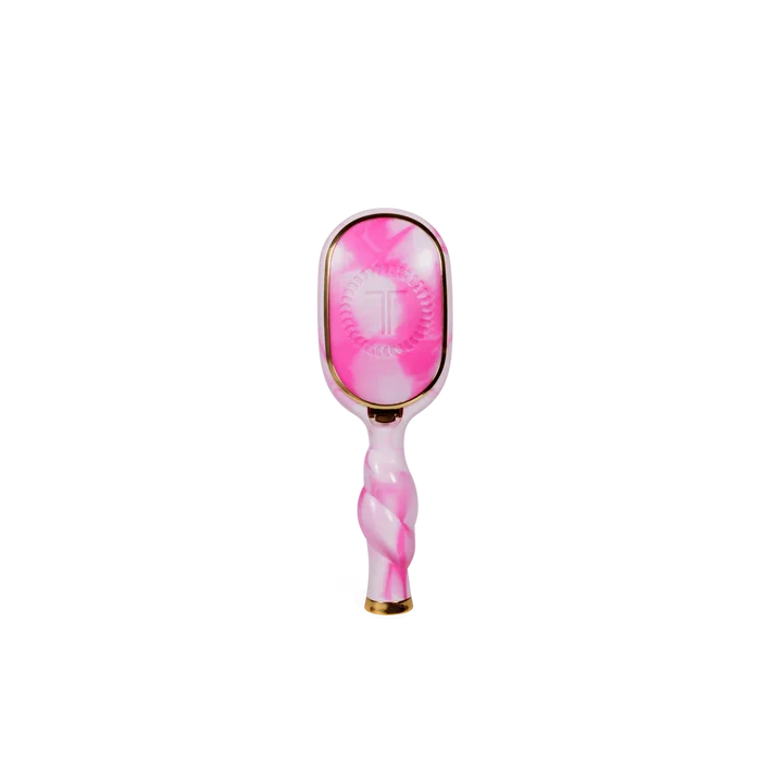 Pink and white hairbrush with gold accents on a white background
