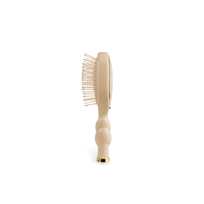 Beige hairbrush on a white background