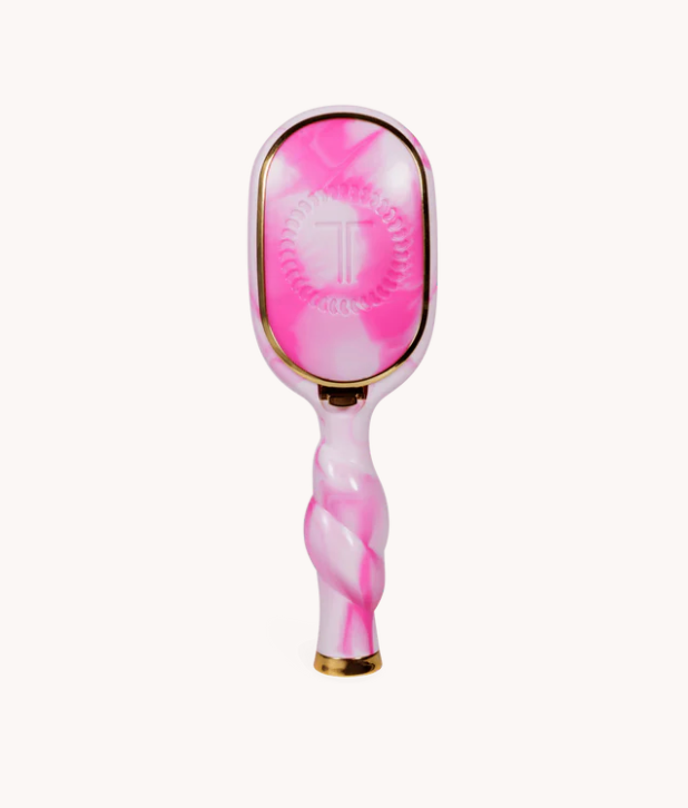 Pink and white marbled hairbrush with gold accents on a white background