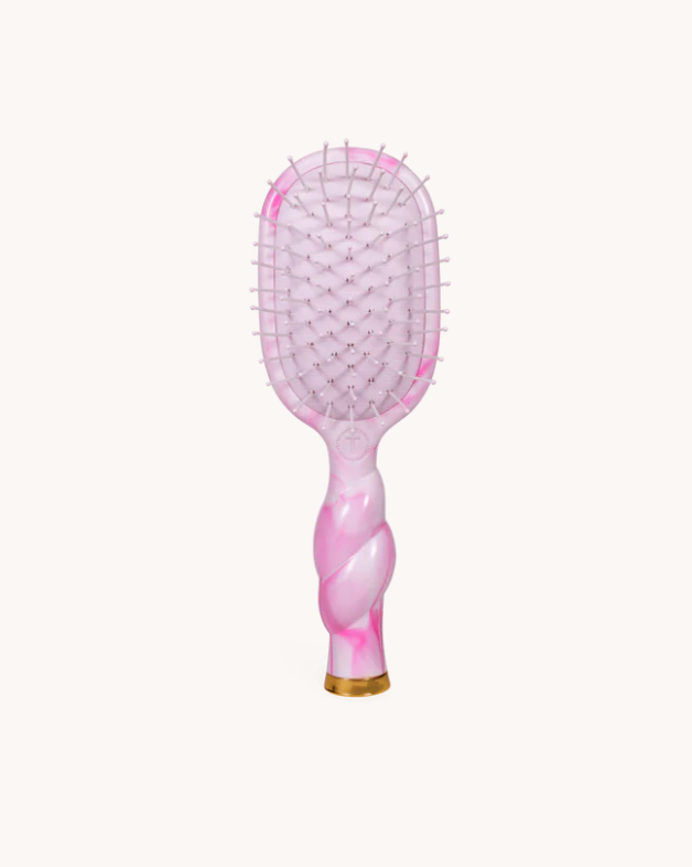 Pink paddle hairbrush on a white background