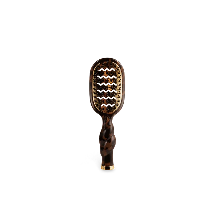 Hairbrush with tortoiseshell handle and wavy pattern on a white background
