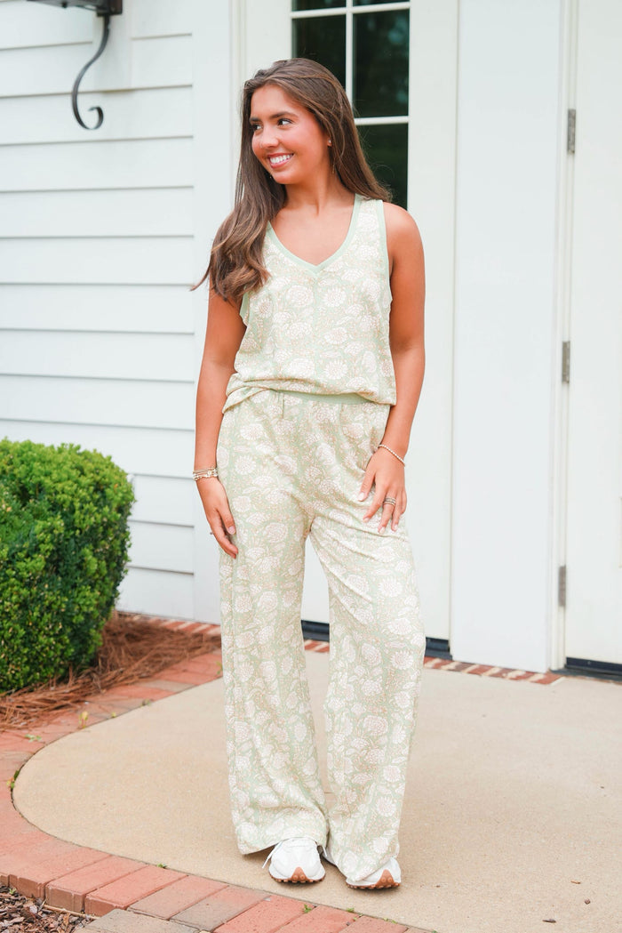 Woman wearing a light-colored lace outfit standing outside a house.