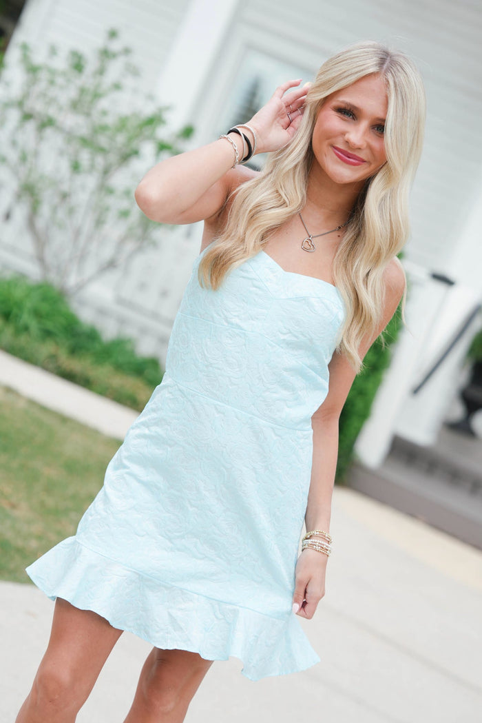Woman wearing a light blue dress outdoors with blurred background