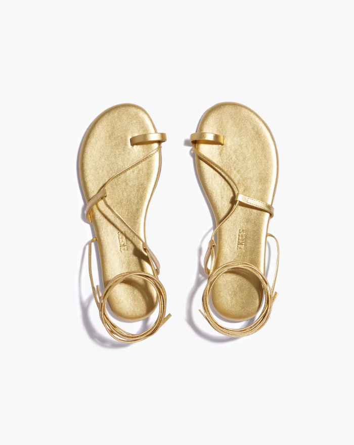 Pair of gold sandals on a white background