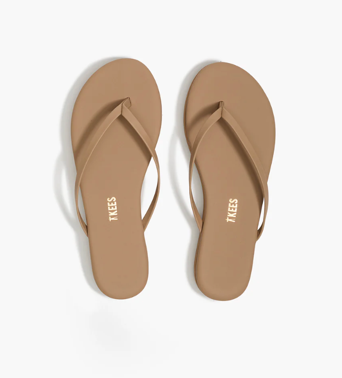 Pair of tan flip-flops with 'Tkees' branding on a white background