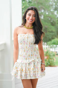Woman wearing a floral dress with a blurred outdoor background