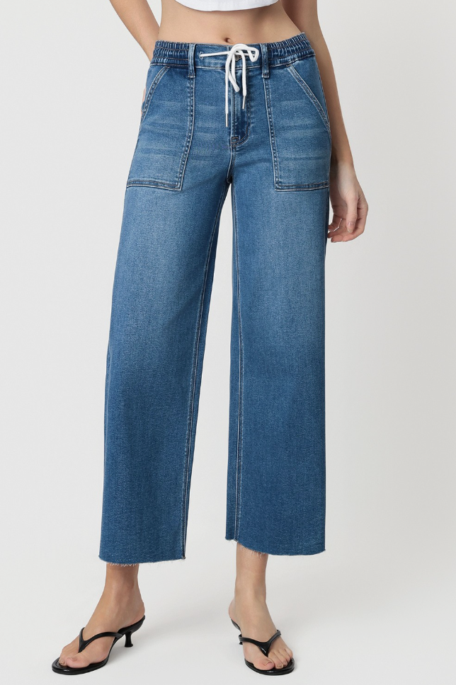 Blue denim wide-leg pants worn by a person on a white background