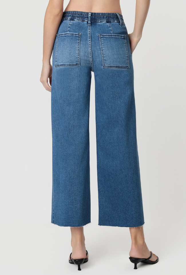 Blue jeans worn by a person on a white background