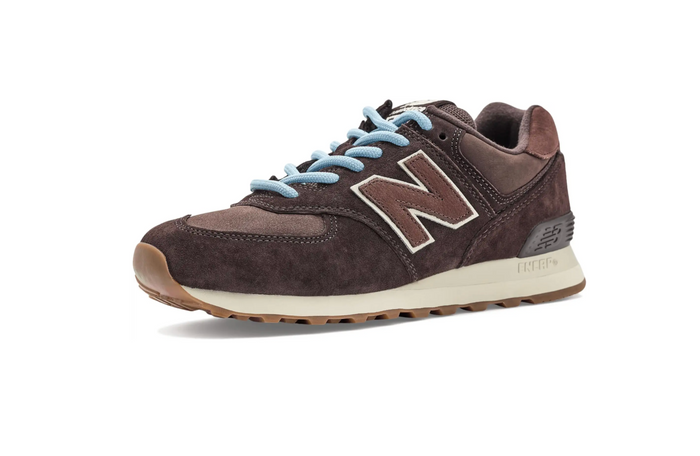 A New Balance sneaker in dark brown suede and leather, featuring light blue laces, a beige and brown 'N' logo, and a cream midsole on a white background.