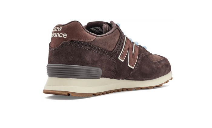 A single New Balance sneaker in dark brown suede and leather, shown from a three-quarters rear angle on a white background.