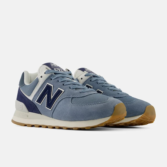 Blue New Balance sneakers with white soles on a light gray background