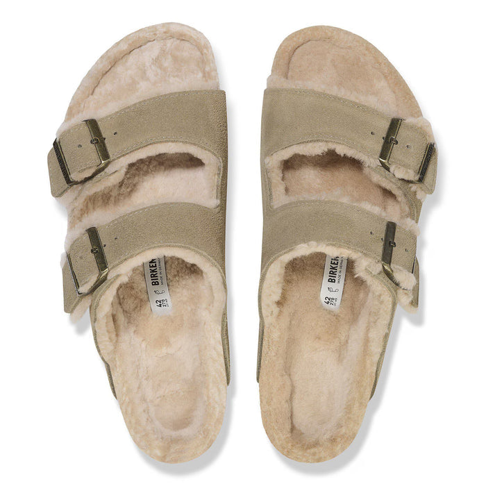 Pair of beige sandals with fur lining on a white background
