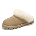 A single slip-on mule slipper in beige suede with a thick, fluffy cream shearling collar and a chunky lug sole, shown on a white background.