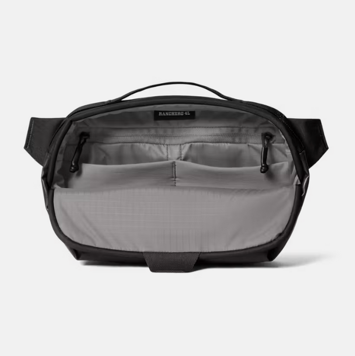 An open black and gray crossbody bag showing its interior organization with multiple zippered pockets and a top handle, photographed on a light gray background.