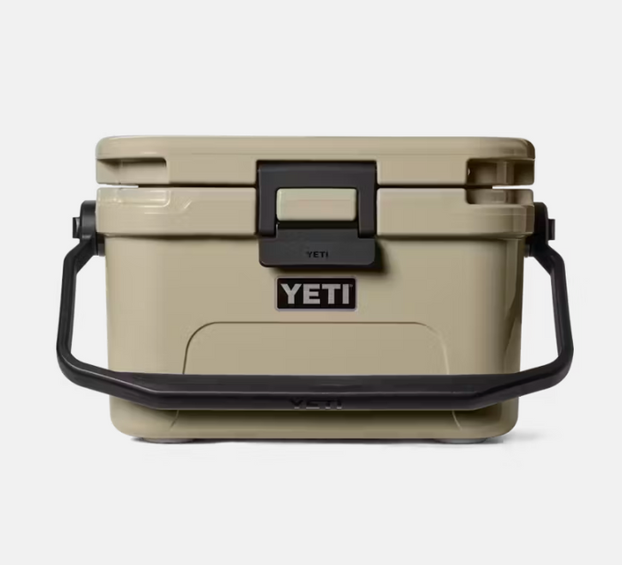 Beige YETI cooler with black handle and lid latch on a white background